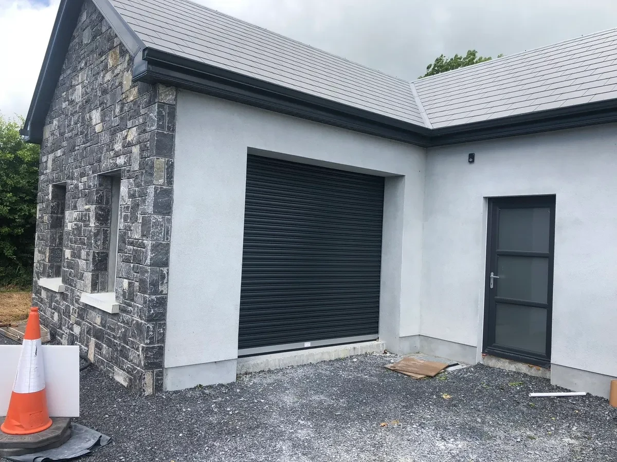 Black roller door stone front garage